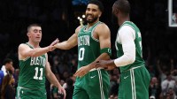 Boston Celtics forward Jayson Tatum (0) smiles at Boston Celtics guard Jaylen Brown (7) while being congratulated by guard Payton Pritchard (11) during the second half at TD Garden.