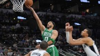 Boston Celtics forward Jayson Tatum (0) shoots the ball against San Antonio Spurs forwards Keldon Johnson (3) and Victor Wembanyama (1) in the second half at Frost Bank Center.