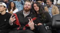 Las Vegas Raiders defensive end Maxx Crosby (left) and wife Rachel Washburn attend the game between the Golden State Warriors and the LA Clippers at the Intuit Dome.