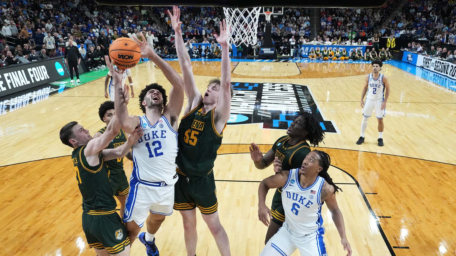 Duke Blue Devils forward Cameron Boozer (12) shoots the ball over Siena Saints center Riley Mulvey (55) in the second half during a first round game of the men's 2026 NCAA Tournament at Bon Secours Wellness Arena.