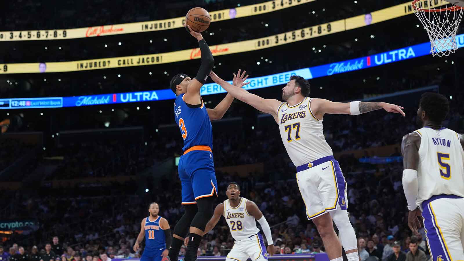 New York Knicks guard Josh Hart (3) shoots the ball against Los Angeles Lakers guard Luka Doncic (77) in the first half at Crypto.com Arena.