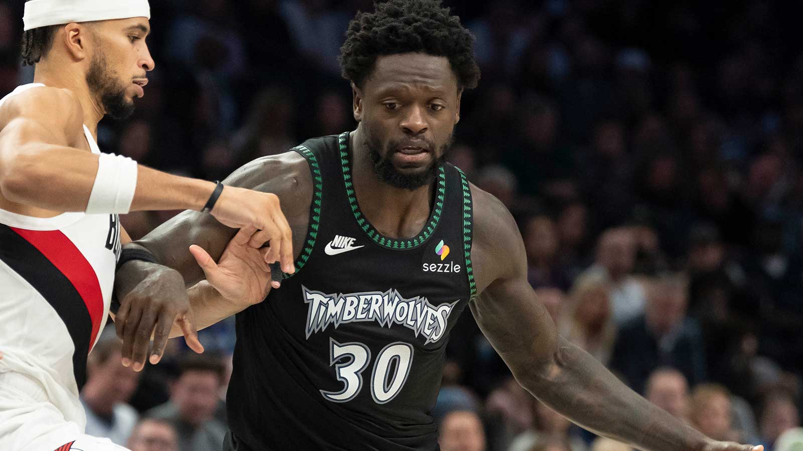 Minnesota Timberwolves forward Julius Randle (30) dribbles the ball as Portland Trail Blazers forward Toumani Camara (33) plays defense in the second half at Target Center. 