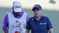 Justin Thomas (right) walks off of the 18th green ahead of his caddie during the first round of the Arnold Palmer Invitational golf tournament at Bay Hill