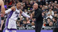 Kings head coach Doug Christie slaps the hand of guard Russell Westbrook (18) during a time out in the first quarter against the Utah Jazz at Delta Center