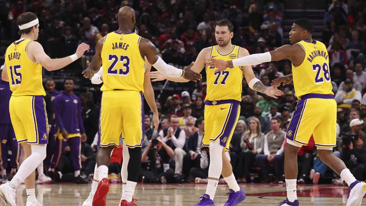 Los Angeles Lakers guard Luka Doncic (77) and forward LeBron James (23) celebrate with teammates after a play during the third quarter against the Houston Rockets at Toyota Center.