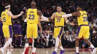 Los Angeles Lakers guard Luka Doncic (77) and forward LeBron James (23) celebrate with teammates after a play during the third quarter against the Houston Rockets at Toyota Center.