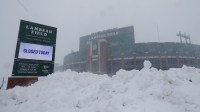 Snow falls around Lambeau Field.