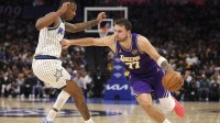 Los Angeles Lakers guard Luka Doncic (77) moves the ball past Orlando Magic forward Jamal Cain (8) in the second quarter at Kia Center.