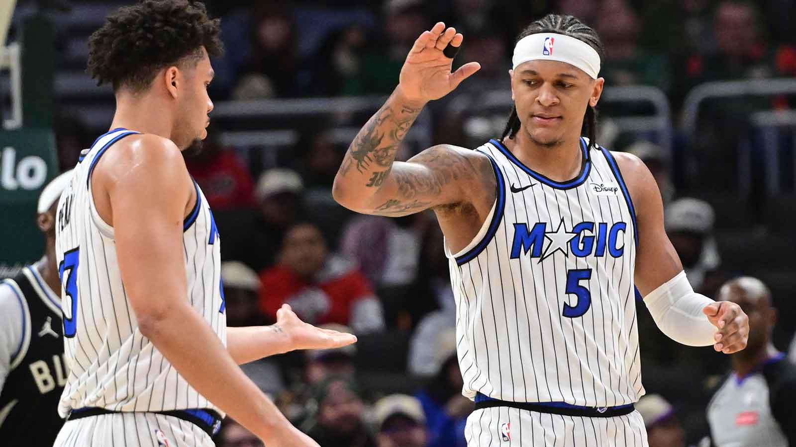 Orlando Magic forward Paolo Banchero (5) reacts with forward Noah Penda (93) after scoring a basket against the Milwaukee Bucks at Fiserv Forum. 