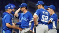 Israel pitcher Matt Bowman (66) hands the ball to manager Brad Ausmus (11) during a pitching change in the seventh inning against the Netherlands at loanDepot Park.