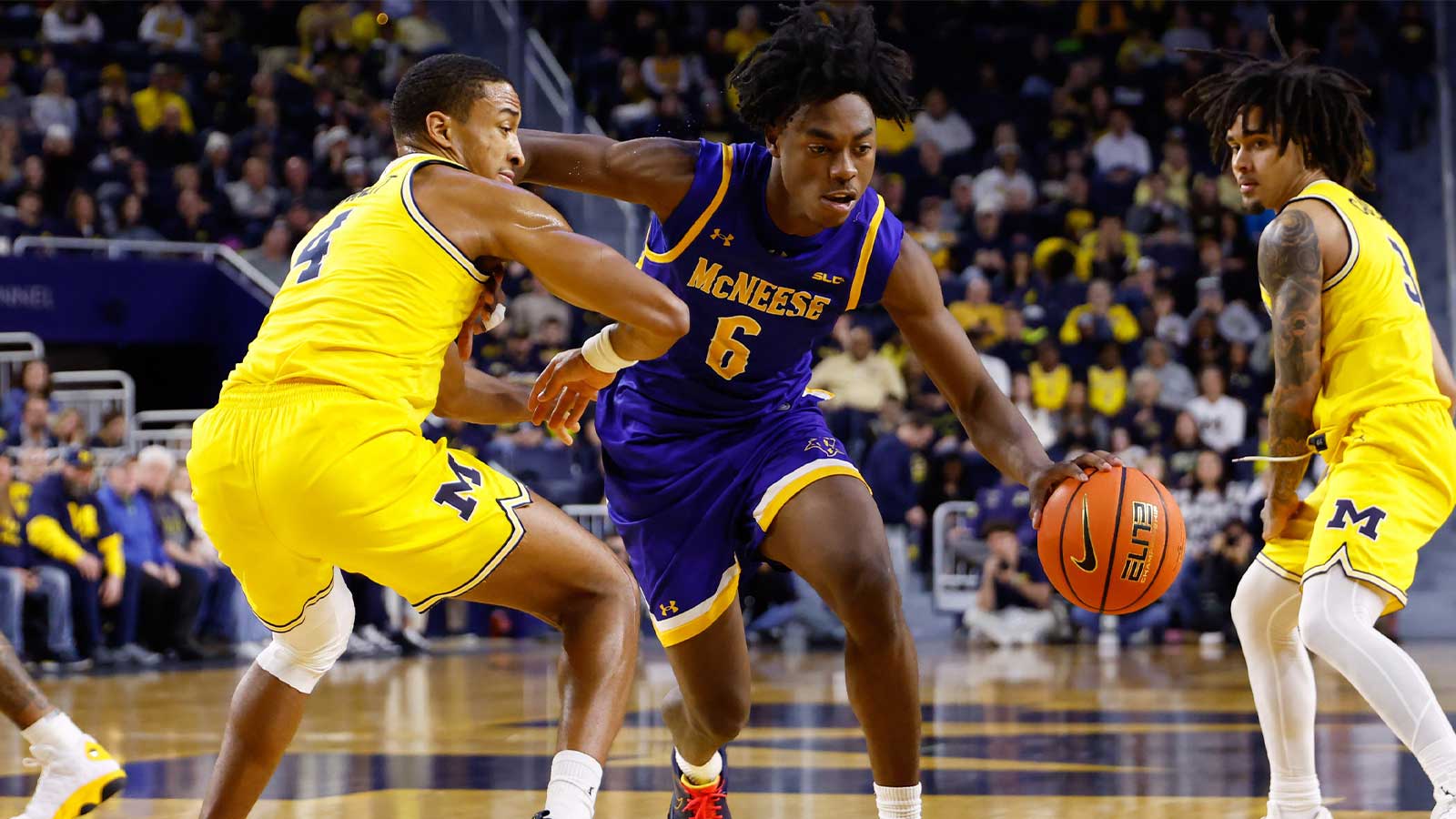 McNeese Cowboys guard Larry Johnson (6) dribbles defended by Michigan Wolverines guard Nimari Burnett (4) at Crisler Center.