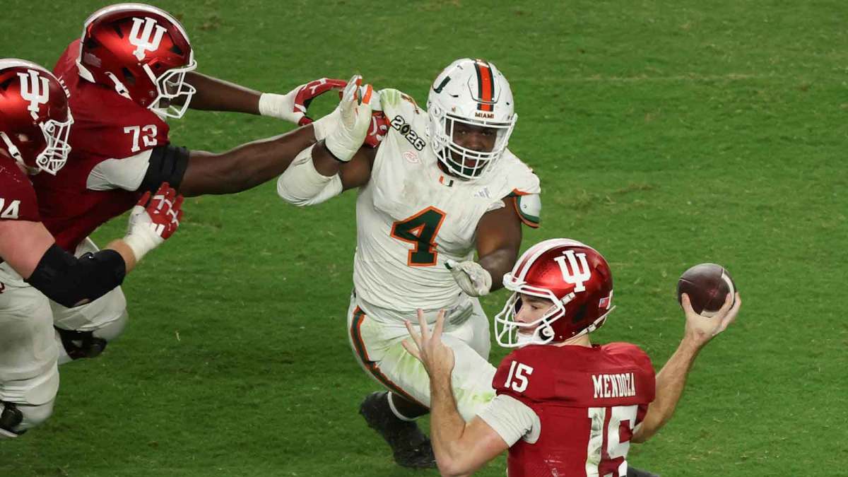 Indiana Hoosiers quarterback Fernando Mendoza (15) passes the ball under pressure by Miami Hurricanes defensive lineman Rueben Bain Jr. (4) in the third quarter during the College Football Playoff National Championship game at Hard Rock Stadium.