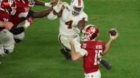 Indiana Hoosiers quarterback Fernando Mendoza (15) passes the ball under pressure by Miami Hurricanes defensive lineman Rueben Bain Jr. (4) in the third quarter during the College Football Playoff National Championship game at Hard Rock Stadium.