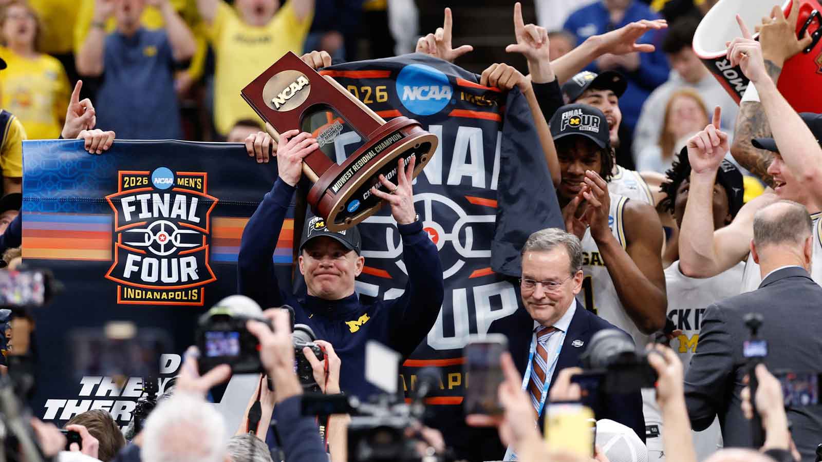 Michigan Wolverines head coach Dusty May lifts the Midwest Regional Champion trophy after defeating the Tennessee Volunteers in an Elite Eight game of the men's 2026 NCAA Tournament at United Center.