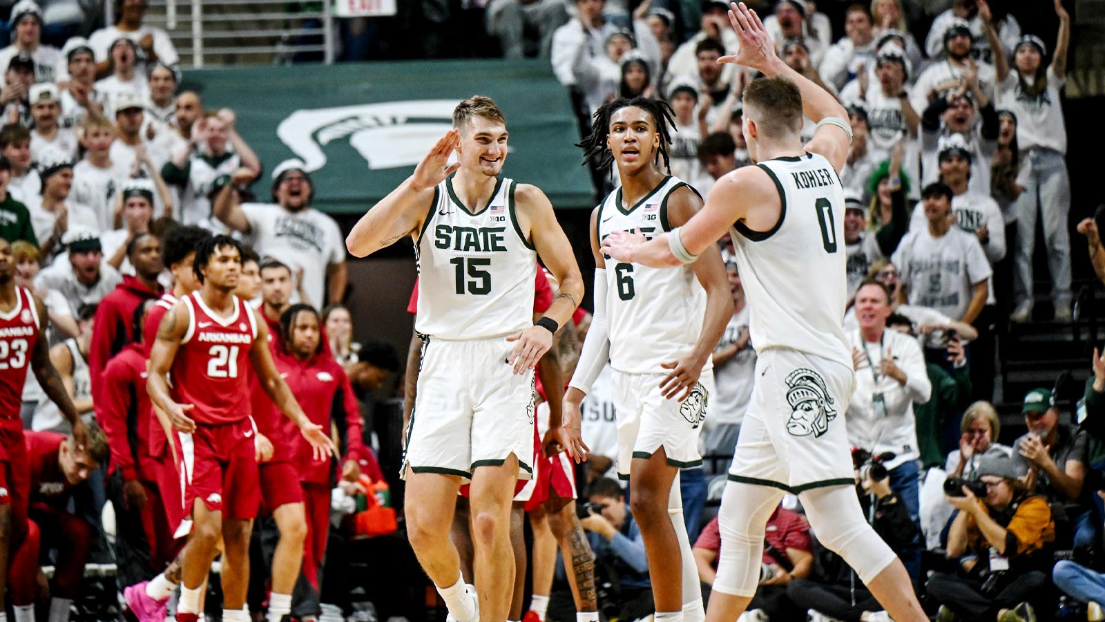 Michigan State's Carson Cooper, left, celebrates with Jaxon Kohler, right, after a score against Arkansas