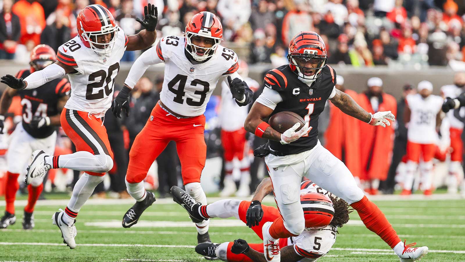 Jan 4, 2026; Cincinnati, Ohio, USA; Cincinnati Bengals wide receiver Ja'marr Chase (1) runs for yards after catch against Cleveland Browns cornerback D'Angelo Ross (20) and linebacker Mohamoud Diabate (43) during the fourth quarter at Paycor Stadium. Mandatory Credit: Joseph Maiorana-Imagn Images