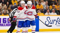 Montreal Canadiens defenseman Alexandre Carrier (45) celebrates his goal with right wing Cole Caufield (13) against the Nashville Predators during the second period Gat Bridgestone Arena.