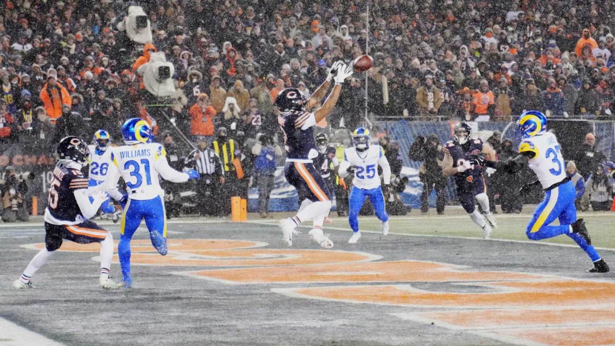 Chicago Bears wide receiver DJ Moore (2) catches a three-yard touchdown pass thrown by quarterback Caleb Williams (not pictured) against Los Angeles Rams safety Quentin Lake (37) and cornerback Darious Williams (31) during the second quarter of an NFC Divisional Round game at Soldier Field.