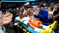 Golden State Warriors guard Moses Moody (4) waves to fans while leaving the court on a stretcher during overtime against the Dallas Mavericks at American Airlines Center.