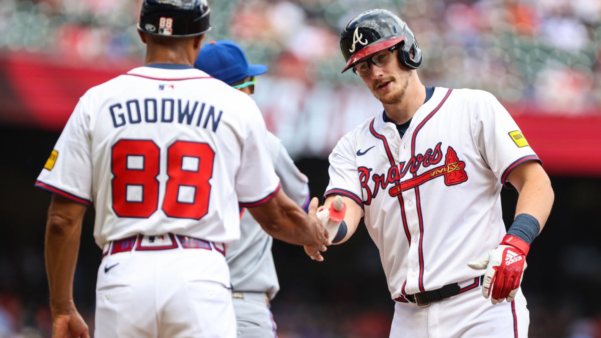 Atlanta Braves catcher Sean Murphy (12) celebrates at first base with Atlanta Braves first base coach Tom Goodwin (88) after a hit against the New York Mets during the second inning at Truist Park.