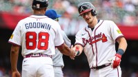 Atlanta Braves catcher Sean Murphy (12) celebrates at first base with Atlanta Braves first base coach Tom Goodwin (88) after a hit against the New York Mets during the second inning at Truist Park.