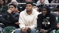 Milwaukee Bucks guard Gary Harris (11), left, Milwaukee Bucks forward Giannis Antetokounmpo (34) and Milwaukee Bucks forward Taurean Prince (12) watch the game against the Cleveland Cavaliers from the bench in the second half at Fiserv Forum.