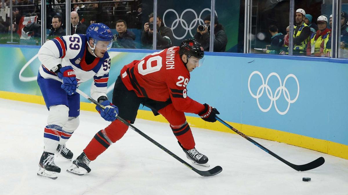 Nathan MacKinnon (29) of Canada is defended by Jake Guentzel (59) of the United States in the men's ice hockey gold medal game during the Milano Cortina 2026 Olympic Winter Games at Milano Santagiulia Ice Hockey Arena.
