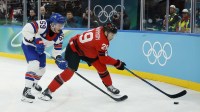 Nathan MacKinnon (29) of Canada is defended by Jake Guentzel (59) of the United States in the men's ice hockey gold medal game during the Milano Cortina 2026 Olympic Winter Games at Milano Santagiulia Ice Hockey Arena.
