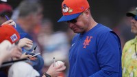New York Mets manager Carlos Mendoza (64) signs autographs at Roger Dean Chevrolet Stadium.
