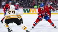 Montreal Canadiens center Nick Suzuki (14) plays the puck against Boston Bruins defenseman Charlie McAvoy (73) during the second period at Bell Centre.