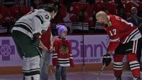 Isaac Vasquez a cancer survivor drops a ceremonial puck with Minnesota Wild left wing Marcus Foligno (17) and Chicago Blackhawks left wing Nick Foligno (17) on a Hockey Fights Cancer at United Center.