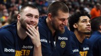 Denver Nuggets guard Christian Braun (0) and center Nikola Jokic (15) laugh on the bench during the first half against the Chicago Bulls at Ball Arena.