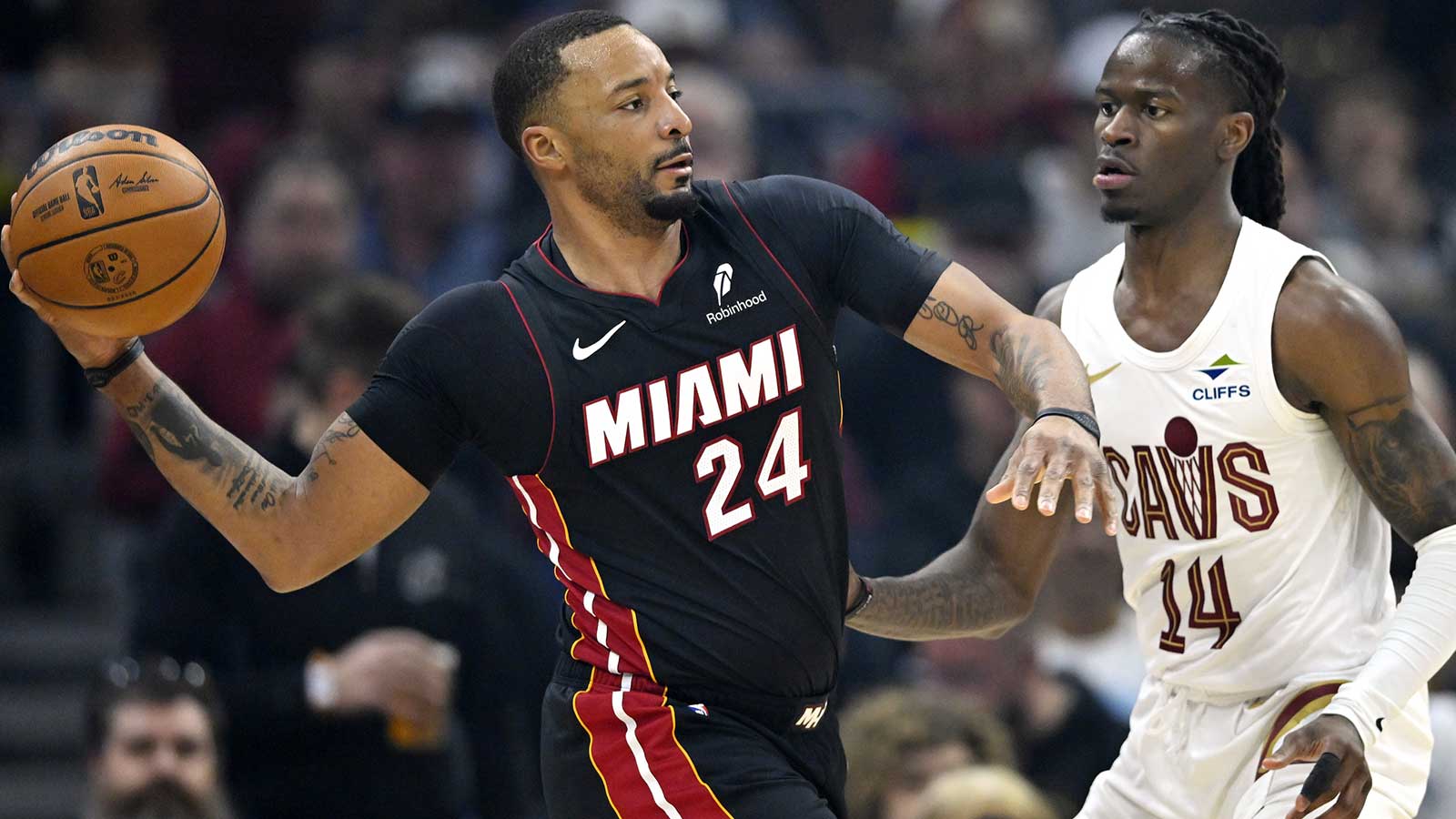 Miami Heat guard Norman Powell (24) looks to pass beside Cleveland Cavaliers guard Keon Ellis (14) in the third quarter at Rocket Arena.