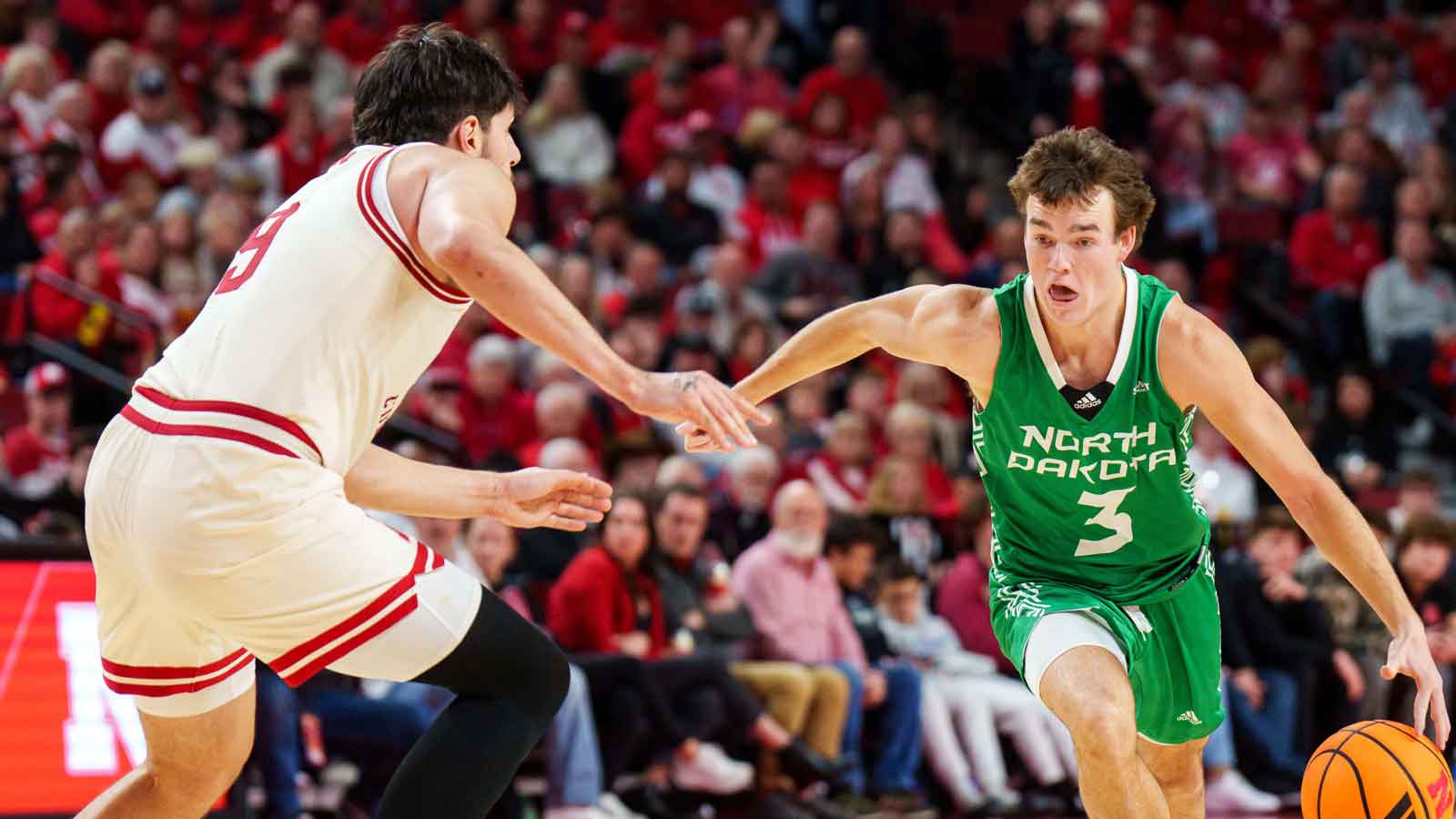 North Dakota Fighting Hawks guard Greyson Uelmen (3) drives against Nebraska Cornhuskers forward Berke Buyuktuncel (9) during the second half at Pinnacle Bank Arena.
