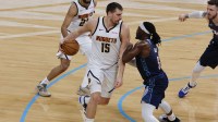Nuggets center Nikola Jokić (15) drives against Oklahoma City Thunder guard Luguentz Dort (5) during the second quarter at Paycom Center with Nuggets' David Adelman in the background