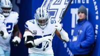 Dallas Cowboys defensive tackle Osa Odighizuwa (97) takes the field with a flag honoring late Dallas Cowboys defensive end Marshawn Kneeland before the game against the New York Giants at MetLife Stadium