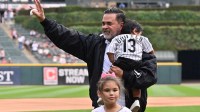 Former Chicago White Sox manager Ozzie Guillen is seen with his family after throwing a ceremonial first pitch out prior to a game against the Cleveland Guardians at Rate Field.