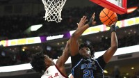 Mar 2, 2026; Raleigh, North Carolina, USA; Duke Blue Devils center Patrick Ngongba II (21) lays the ball up against NC State Wolfpack guard Paul McNeil Jr. (2) during the second half at Lenovo Center. Mandatory Credit: