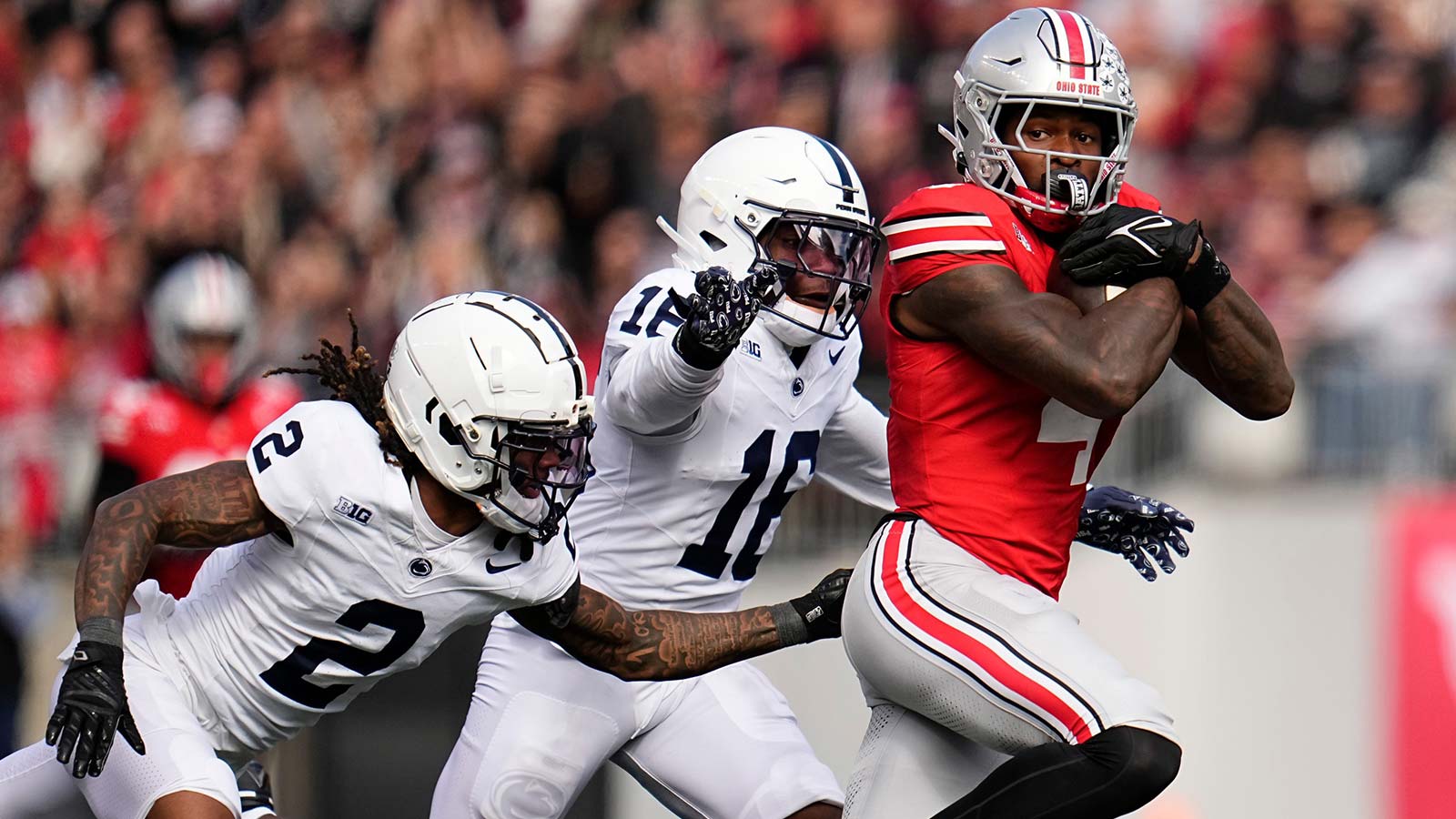 Ohio State Buckeyes wide receiver Jeremiah Smith (4) catches a pass in front of Penn State Nittany Lions safety King MacK (16) and cornerback Audavion Collins (2) during the NCAA football game against the Penn State Nittany Lions at Ohio Stadium in Columbus on Nov. 1, 2025.