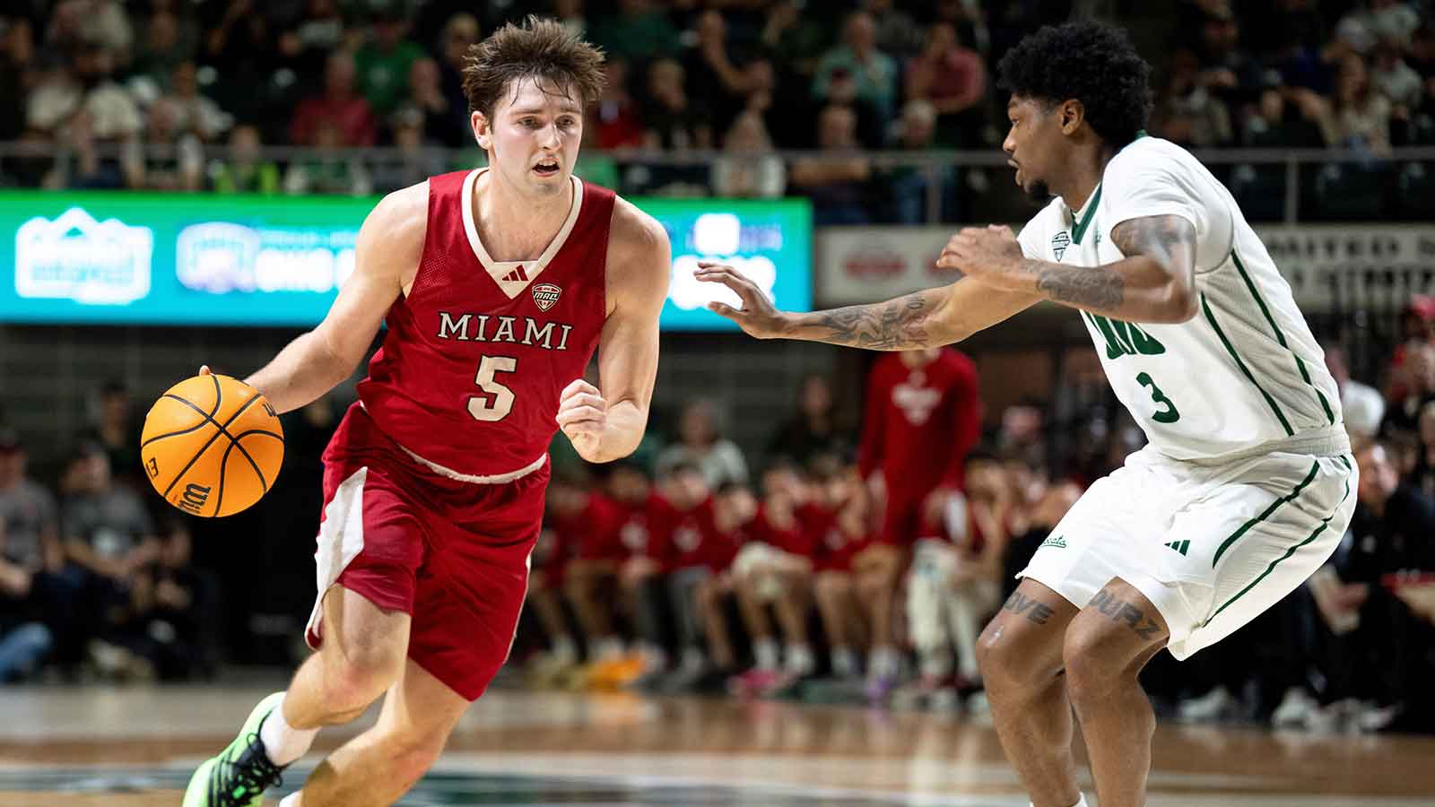 Miami RedHawks guard Peter Suder (5) drives on Ohio Bobcats guard Dior Conners (3) in the first half of the MAC conference final game at the Convocation Center in Athens, Ohio, on Friday, March 6, 2026.