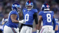 New York Giants linebacker Brian Burns (0) celebrates after a sack against the Philadelphia Eagles with defensive tackle Dexter Lawrence II (97) and safety Jevon Holland (8) during the first quarter of the game at MetLife Stadium.