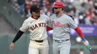 San Francisco Giants shortstop Willy Adames (2) and Philadelphia Phillies first baseman Bryce Harper (3) embrace at the end of the first inning at Oracle Park.