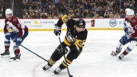 Pittsburgh Penguins center Sidney Crosby (87) moves the puck against Colorado Avalanche center Brock Nelson (11) and right wing Valeri Nichushkin (13) during the third period