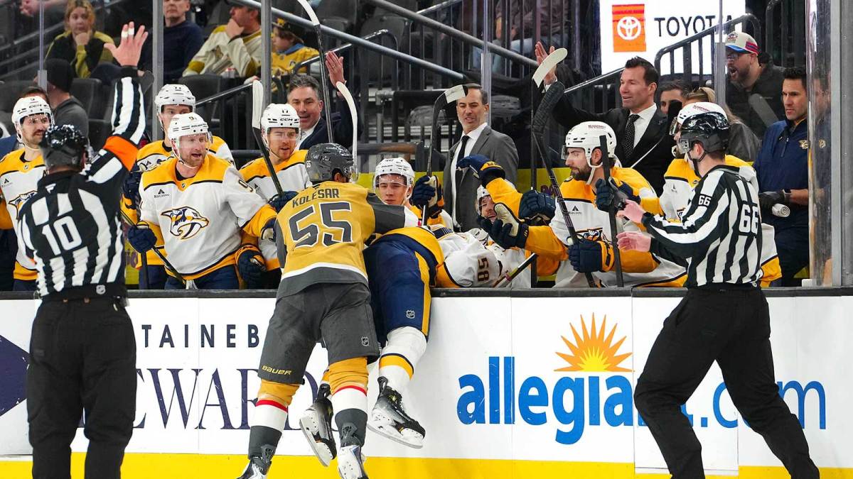 Vegas Golden Knights right wing Keegan Kolesar (55) checks Nashville Predators left wing Michael Bunting (58) into the bench during the second period at T-Mobile Arena.