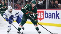 Minnesota Wild defenseman Quinn Hughes (43) skates with the puck alongside Toronto Maple Leafs right wing Pontus Holmberg (29) at Grand Casino Arena.
