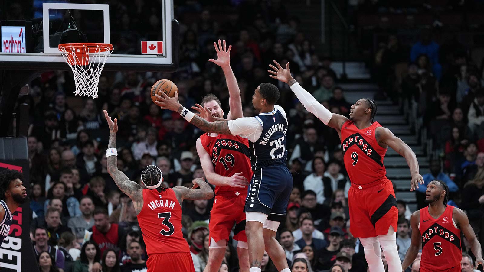 Dallas Mavericks forward P.J. Washington (25) drives to the basket as Toronto Raptors center Jakob Poeltl (19) tries to defend during the fourth quarter at Scotiabank Arena.