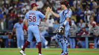 Philadelphia Phillies pitcher Tanner Banks (58) celebrates with Philadelphia Phillies catcher J.T. Realmuto (10) after the game against the Los Angeles Dodgers during game three of the NLDS round for the 2025 MLB playoffs at Dodger Stadium