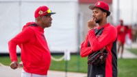 Cincinnati Reds pitcher Hunter Greene (21) talks with special assistant to the general manager, Eric Davis.