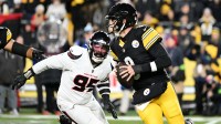 Pittsburgh Steelers quarterback Aaron Rodgers (8) scrambles from Houston Texans defensive end Derek Barnett (95) during the first half of an AFC Wild Card Round game at Acrisure Stadium.