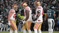 San Francisco 49ers running back Christian McCaffrey (23) celebrates his touchdown with guard Dominick Puni (77) and center Jake Brendel (64) during the fourth quarter against the Philadelphia Eagles in an NFC Wild Card Round game at Lincoln Financial Field.
